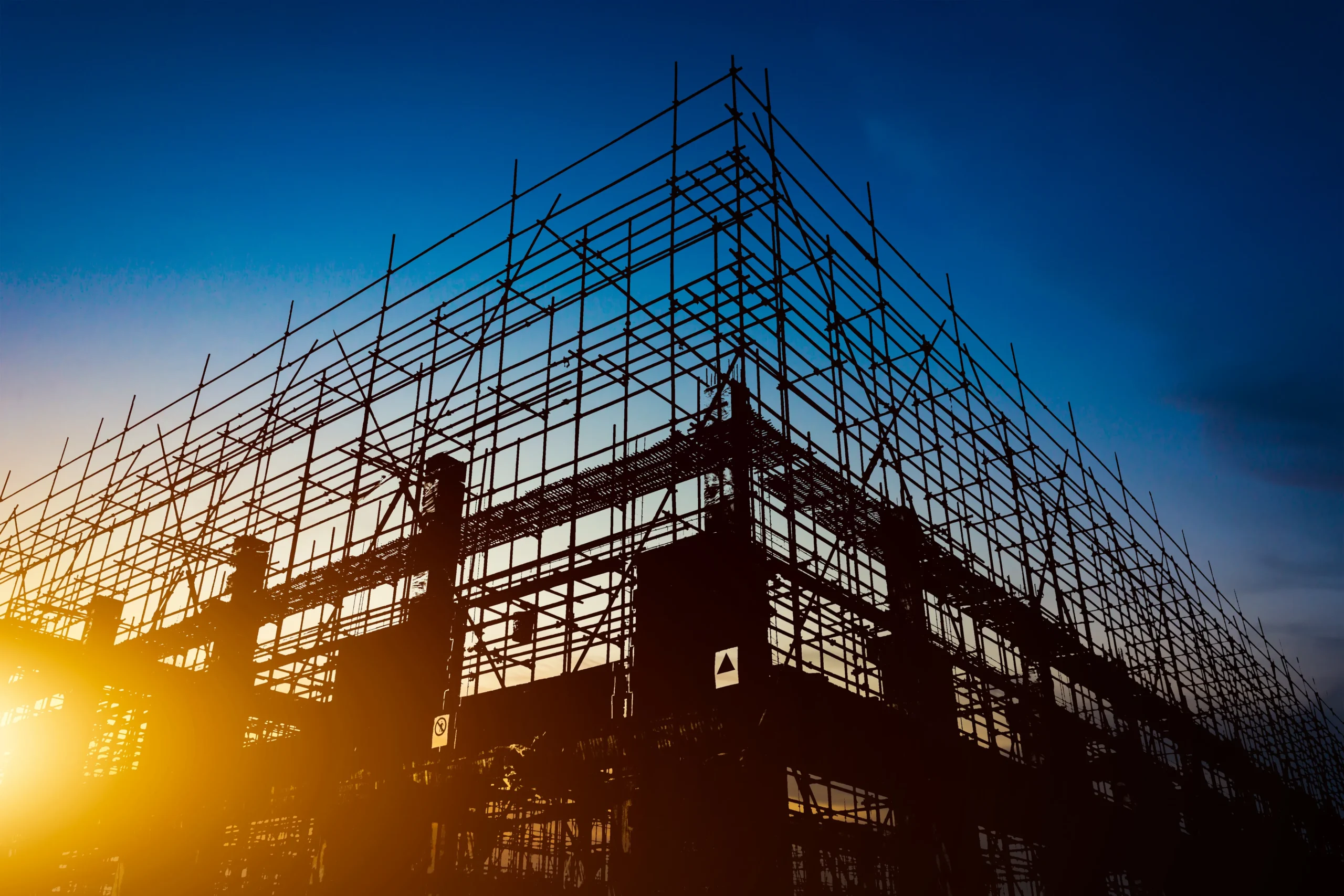 Construction site with scaffolding at sunset, representing construction and building services